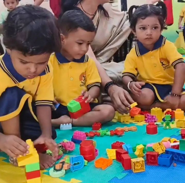 Happy preschool children playing with colorful wooden blocks